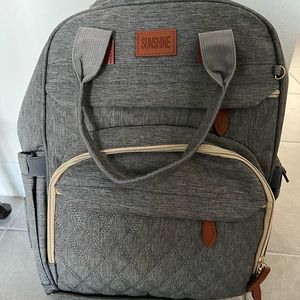 Gray diaper bag that doubles as a traveling bassinet.